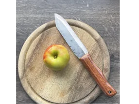 Apfel und Messer auf Holzbrett