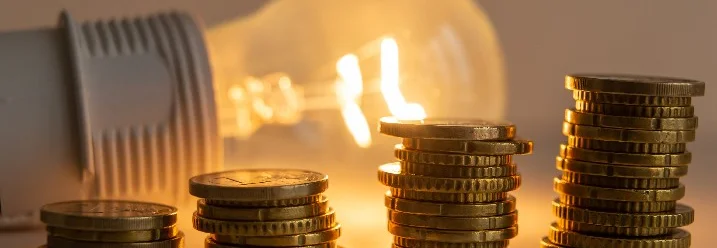 Steigende Geldstapel und eine Glühbirne