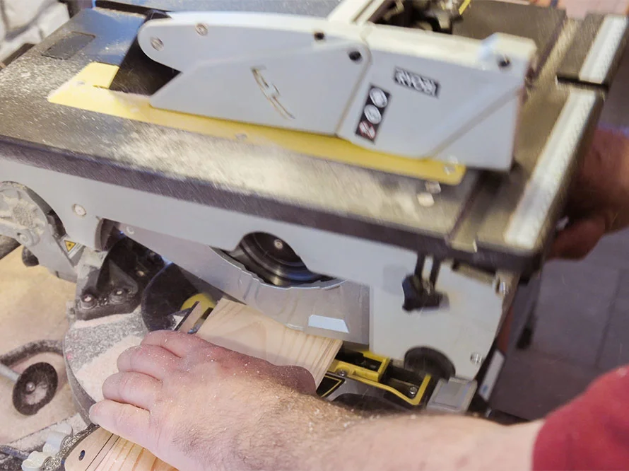 Person sägt Holz mit Kappsäge