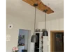 Drei schwarze Hängelampen an Holzbalken