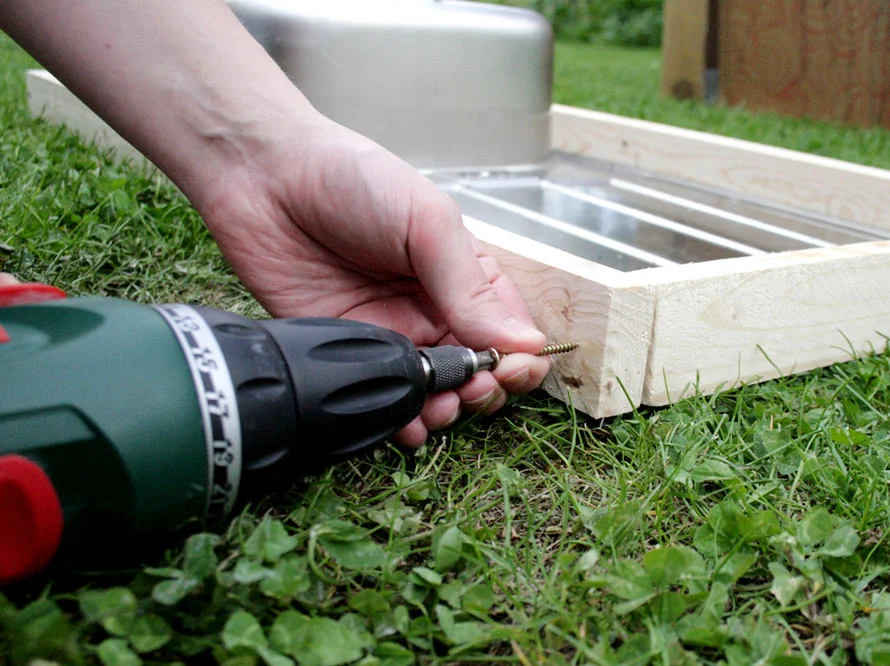 Person verschraubt Holzbalken mit Akkuschrauber