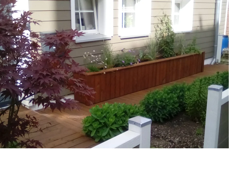 Holzblumenkasten an Hauswand mit Pflanzen