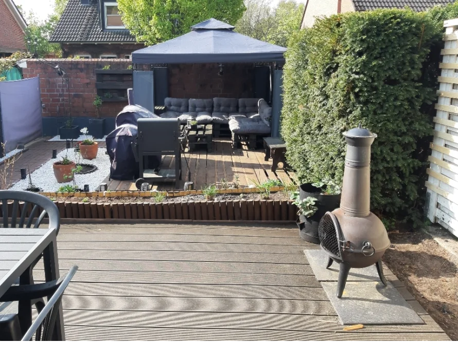 Terrasse mit Gartenmöbeln und Grill