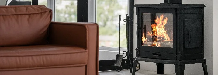 Ein brennender Kaminofen in einem Wohnzimmer.