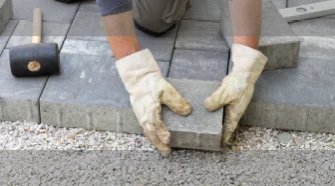 Pflasterarbeiten mit Wasserwaage im Garten