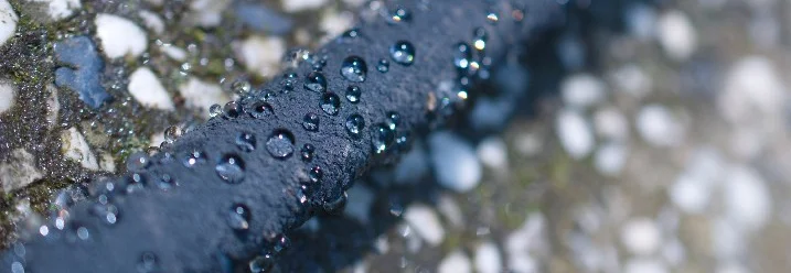 Gartenschlauch mit Wassertropfen