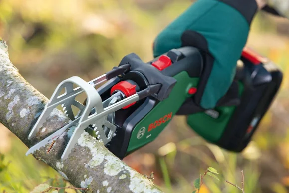 Akku-Astsäge beim Sägen eines Astes