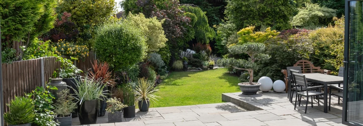 Terrasse mit Gartenmöbeln und Garten