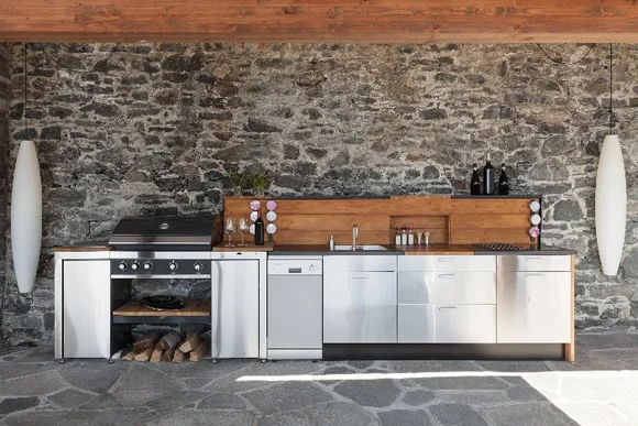 Außenküche mit Grill vor Steinwand