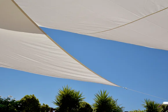 Zwei Sonnensegel vor blauem Himmel