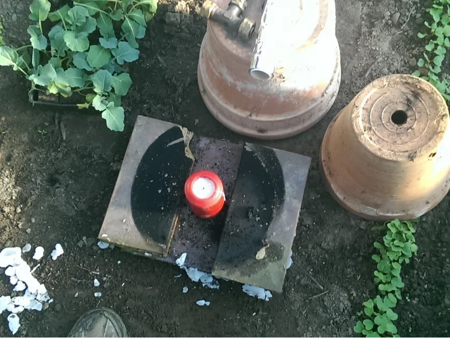 Rote Kerze auf Ziegeln im Garten