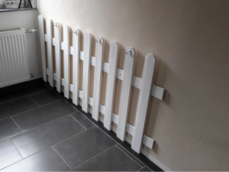 Weißer Lattenzaun an Wand