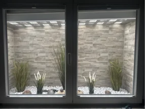 Fensterbank mit Dekogras und Steinen