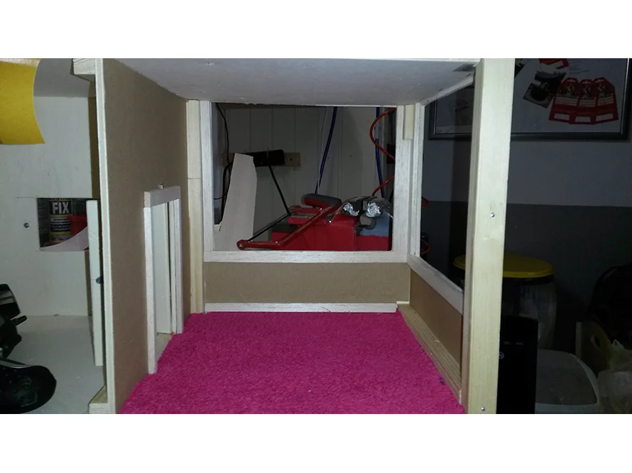 Rohbau eines Puppenhauses mit rosa Teppich
