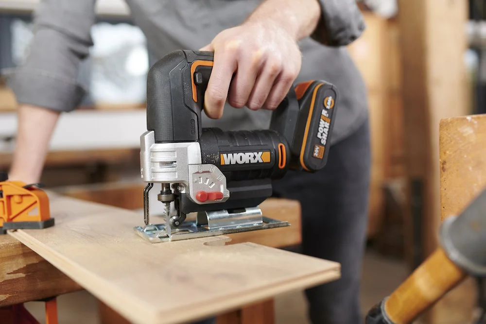 Person schneidet mit Stichsäge in Holz