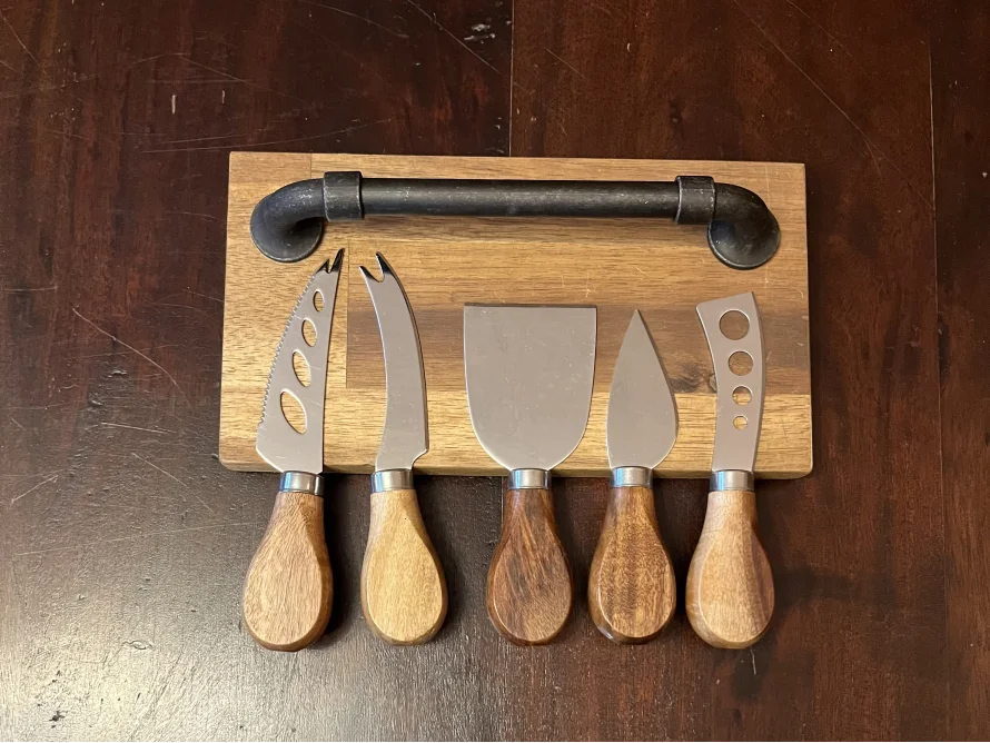 Käsemesserset mit Holzgriffen auf einem Holzbrett