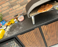 Pizza wird aus Pizzaofen geholt