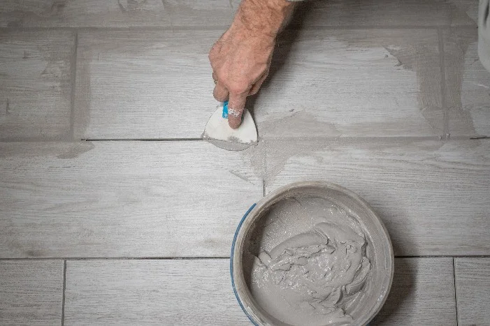Person verfugen Fliesen mit Kelle