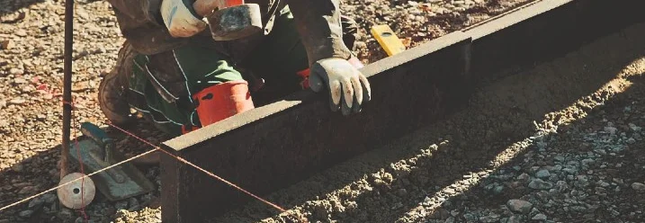 Person befestigt Metallschiene mit Hammer