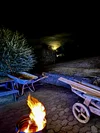 Lagerfeuer im Garten bei Nacht mit Schubkarre und Mondschein.