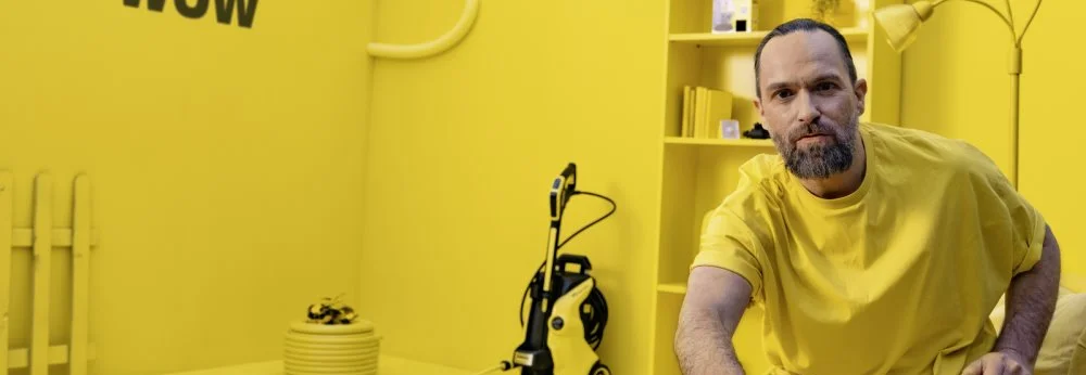 Person reinigt gelben Tisch