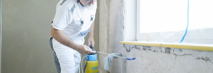 Person trägt Flüssigkeit mit Sprühflasche auf