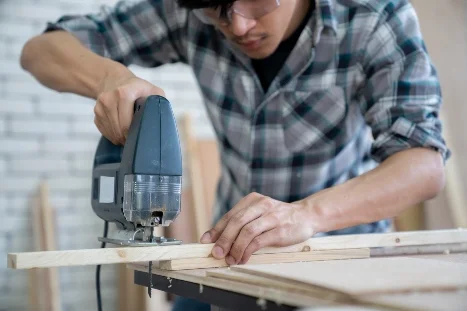 Person sägt Holz mit Stichsäge