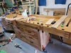 Eine robuste Holzwerkbank in einer unordentlichen Werkstatt.