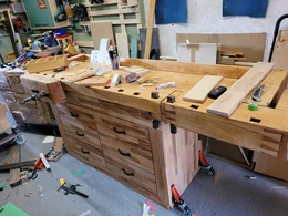 Eine robuste Holzwerkbank in einer unordentlichen Werkstatt.