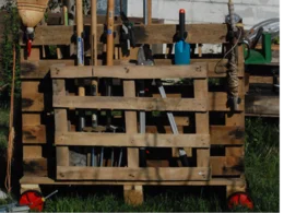 Gartenwerkzeug an einer Palette aufbewahrt