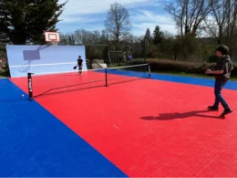 Zwei Personen spielen Padel-Tennis im Garten.
