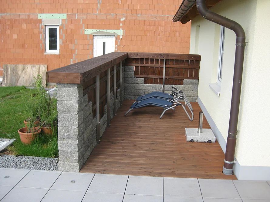 Holzterrasse mit zwei Liegestühlen