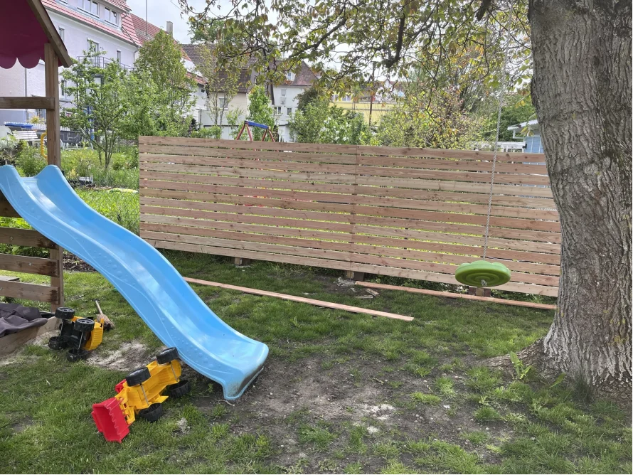 Garten mit Spielzeug und Holzzaun