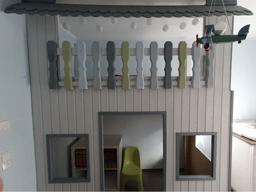 Hölzernes Hochbett in Form eines Spielhauses