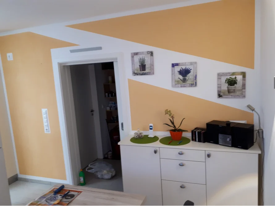 Wand mit Bildern und Sideboard