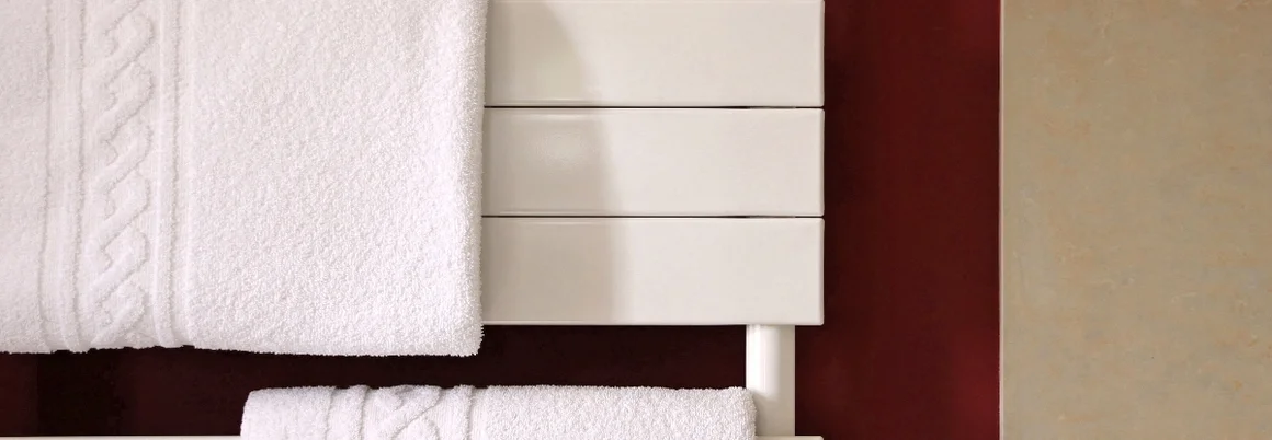 Zwei weiße Handtücher auf einem weißen Handtuchwärmer