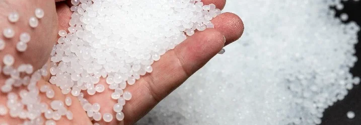 Hand hält weiße Kunststoffgranulate