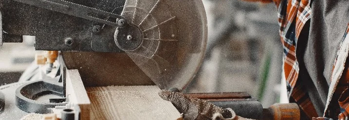 Person sägt Holz mit Kreissäge