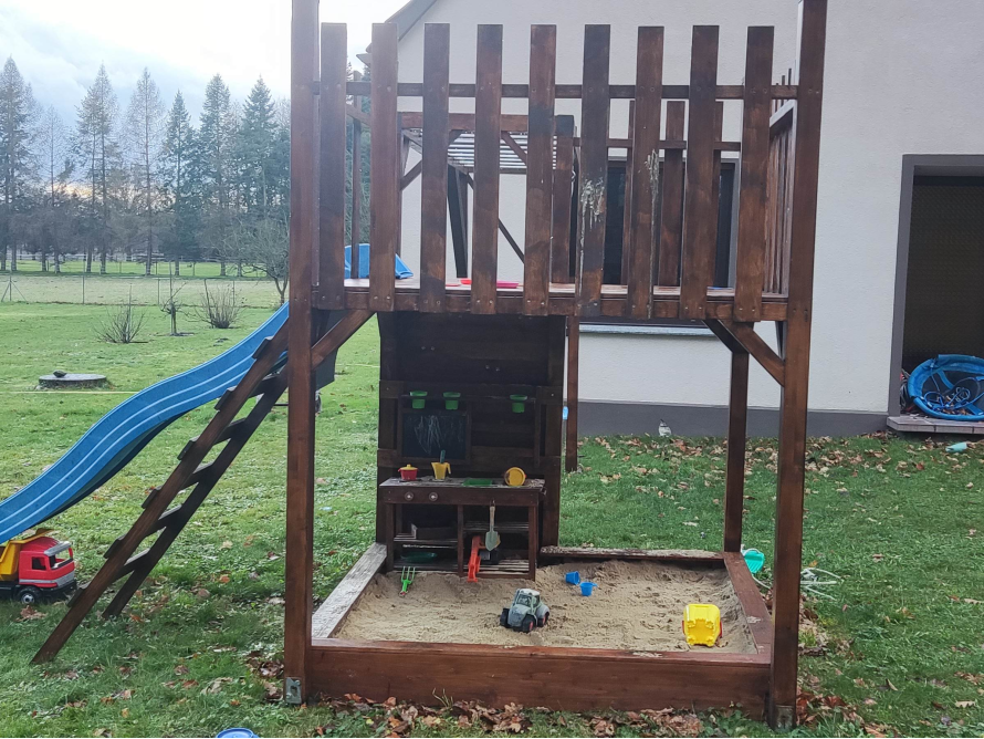 Holzspielplatz mit Rutsche und Sandkasten