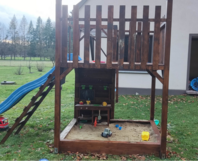 Holzspielplatz mit Rutsche und Sandkasten