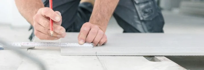 Person vermisst Fliese mit Bleistift und Zollstock