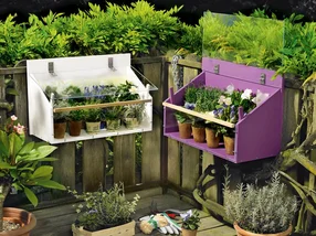 Zwei Blumenkästen an einem Gartenzaun