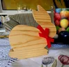 Ein hölzerner Osterhase mit einer roten Schleife steht als Dekoration auf einem Tisch.