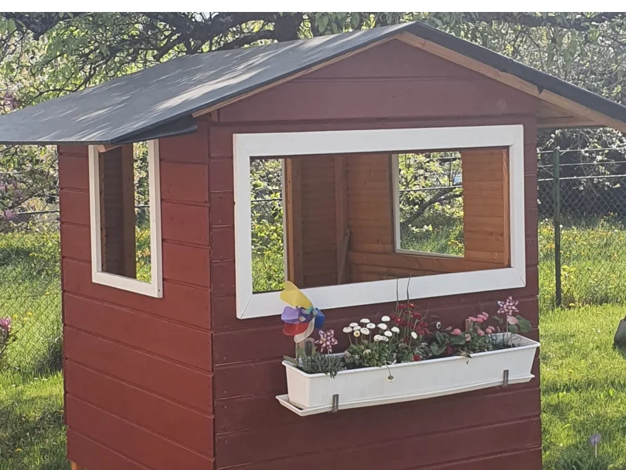 Rotes Gartenhaus mit Blumenkasten