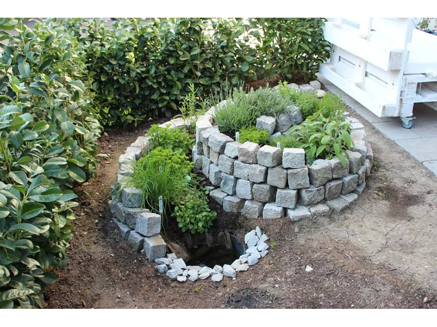 Spiralenförmiges Hochbeet aus Granitsteinen