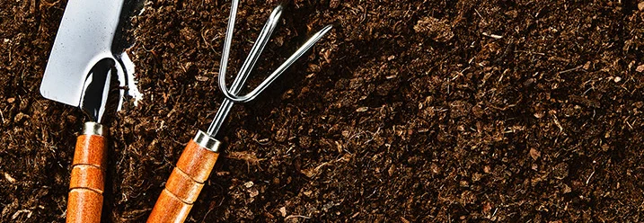 Handschaufel und Handrechen auf Erde