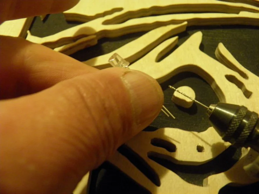 Person hält LED-Lampe an Sperrholz