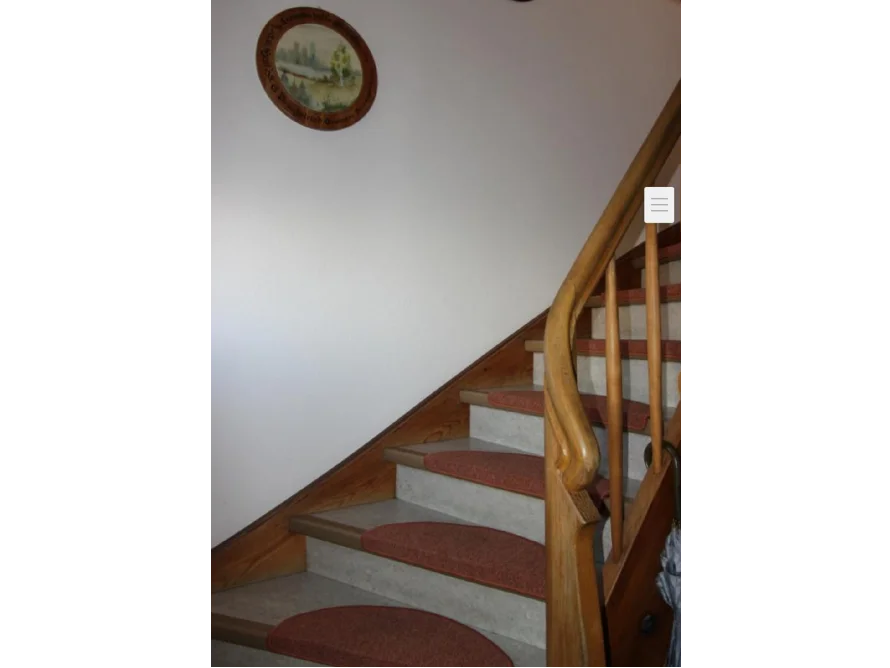 Hölzerne Treppe mit roten Stufenmatten