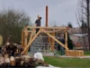 Zwei Personen bauen ein Gartenhaus aus Holz
