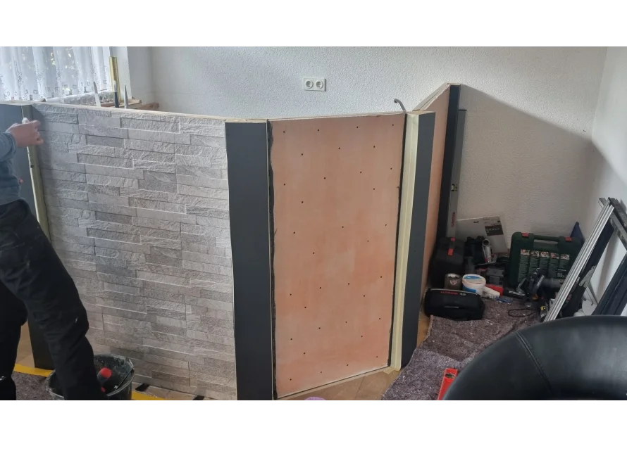 Person baut eine Trennwand aus Rigips